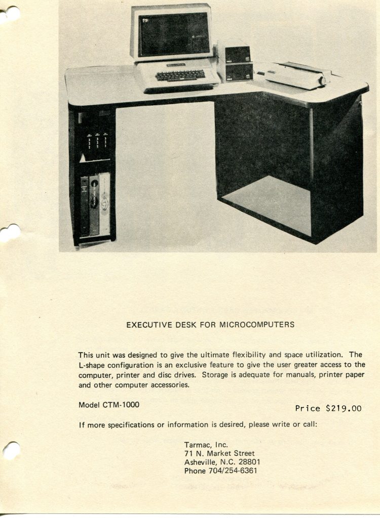 This is a document about an L-shaped executive desk for microcomputers. The page shows a black and white photo of the desk holding a vintage monitor and keyboard, two stacked disk drives, and a dot matrix printer. Shelves on the left store binders and manuals. Headline reads EXECUTIVE DESK FOR MICROCOMPUTERS. Text describes flexibility, space utilization, and storage for manuals and printer paper. It lists Model CTM-1000, price 219.00, and contact info for Tarmac, Inc., 71 N. Market Street, Asheville, N.C. 28801, phone 704/254-6361.